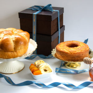 Rosh Hashana Gift box with honey cake, jar of honey, Challah, honey dropper, and dried apples and apricots