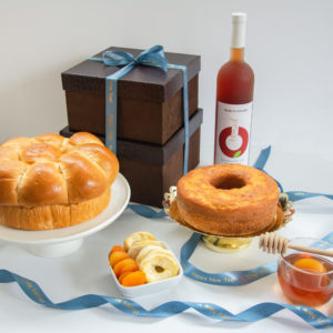 Rosh Hashana Gift box with honey cake, wine, jar of honey, Challah, honey dropper, and dried apples and apricots