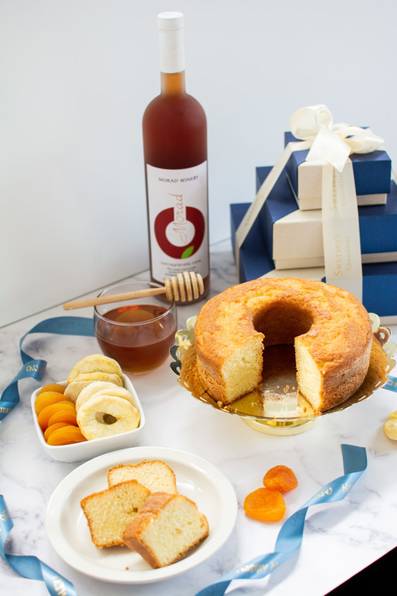 Rosh hashana gift box with honey cake, honey, honey dropper, dried apples and apricots and Israeli pomegranate wine